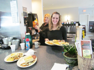 Tracy Fox, right, manager and head waitress at Wade’s Diner in Oswego, joins server Kirstie DeGrande during a recent morning rush.