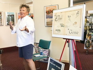 SUNY Oswego’s Amy Bartell, coordinator of community art exhibitions, discusses “Art and Activism: Issues, Images and the Ways We Make Change” during a recent We Are Lake Ontario exhibition. The exhibition and speaker series, held at Oswego State Downtown, is part of the college’s Grand Challenges Project: Fresh Water for All. Photo courtesy of Kristi Eck, SUNY Oswego.